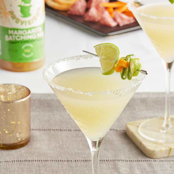 A glass of Top Hat Provisions Agave Margarita with lime slices on top.