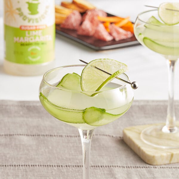 A glass of Top Hat Provisions sugar-free margarita mix with a lime wedge.