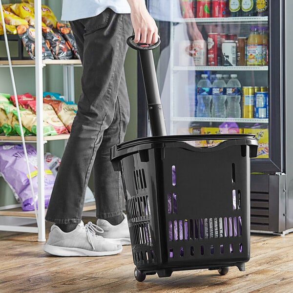 A man using a Regency shopping basket with wheels on it to push a shopping cart.