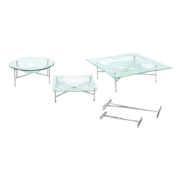 A Front of the House stainless steel riser on a glass table with metal legs.