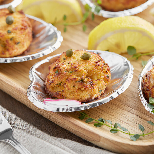 Royal Paper King Foil Clam Shells filled with food on a wooden tray.