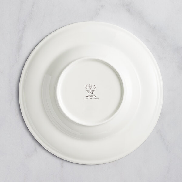 A white RAK Porcelain deep plate with an embossed crown on the rim.