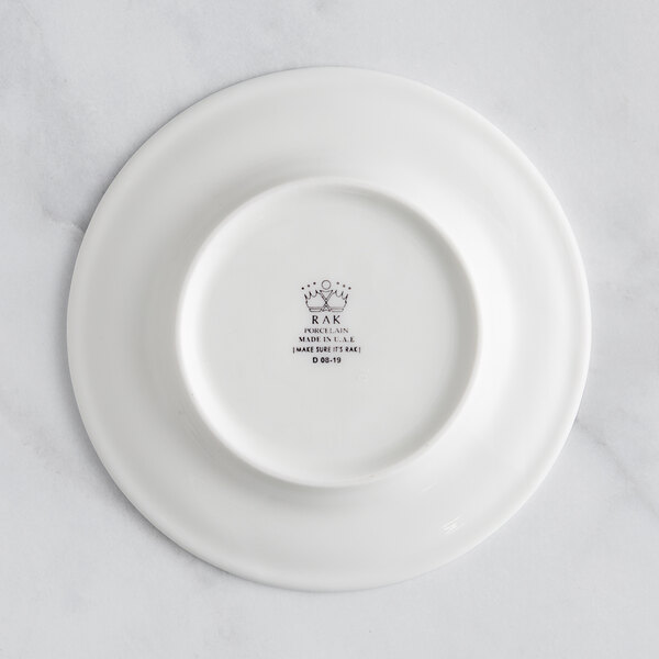 A white RAK Porcelain flat plate with an embossed crown on the rim.