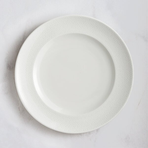 A RAK Porcelain ivory flat plate with an embossed rim.