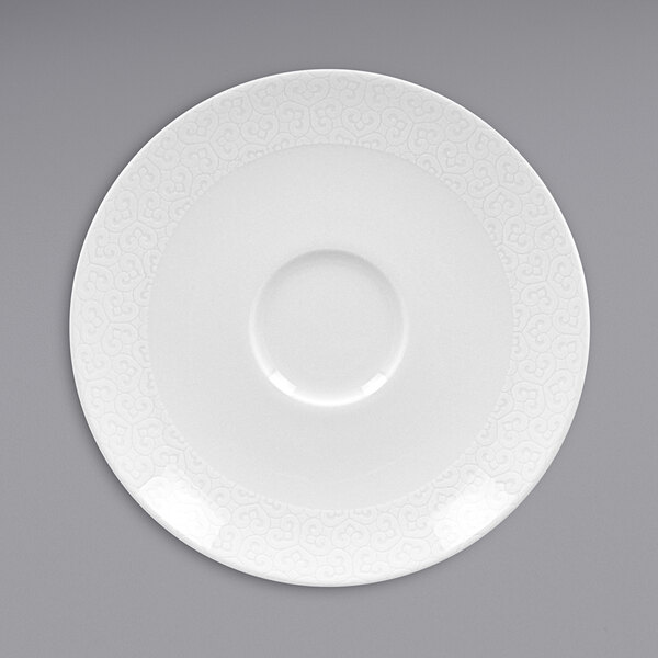 A white RAK Porcelain saucer with a circular edge and embossed pattern.