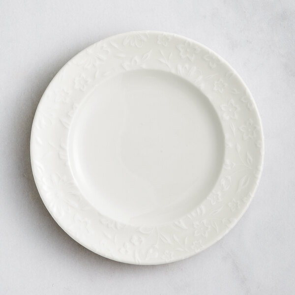 A white RAK Porcelain plate with embossed flowers.