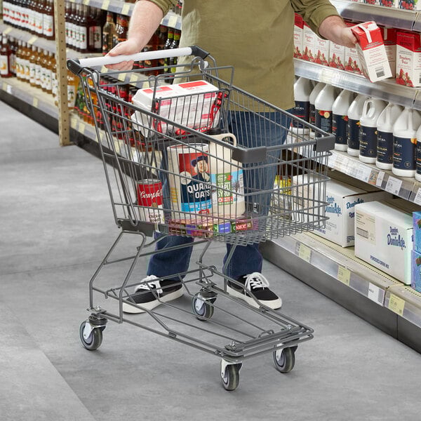 A man pushing a Regency Supermarket shopping cart in a grocery store aisle.
