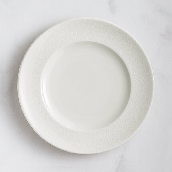 A RAK Porcelain ivory flat plate with an embossed pattern.