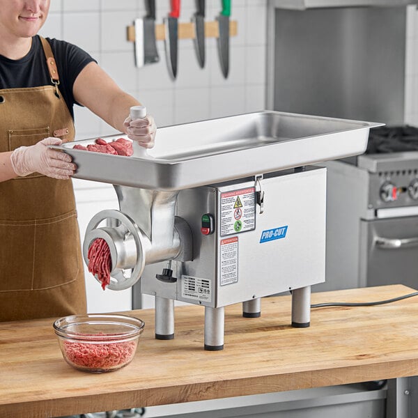A woman using a ProCut electric meat grinder on a kitchen counter.