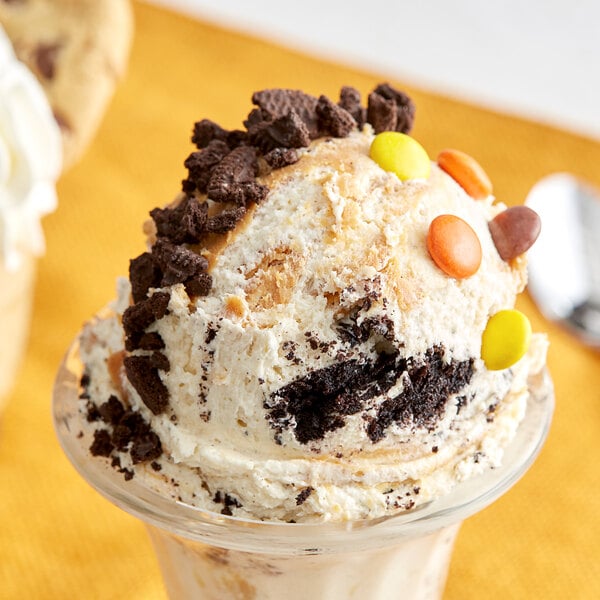 A scoop of Cookie Dough Bliss peanut butter and cookies cookie dough on a bowl of ice cream.