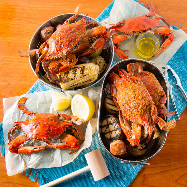 A bowl of Chesapeake blue crab and corn on the cob with a lemon half and nutcracker.