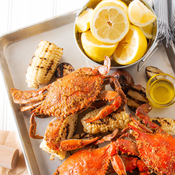 A tray of Chesapeake crabs with corn and lemon wedges.