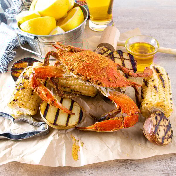 A Chesapeake blue crab on a plate with corn and lemons.