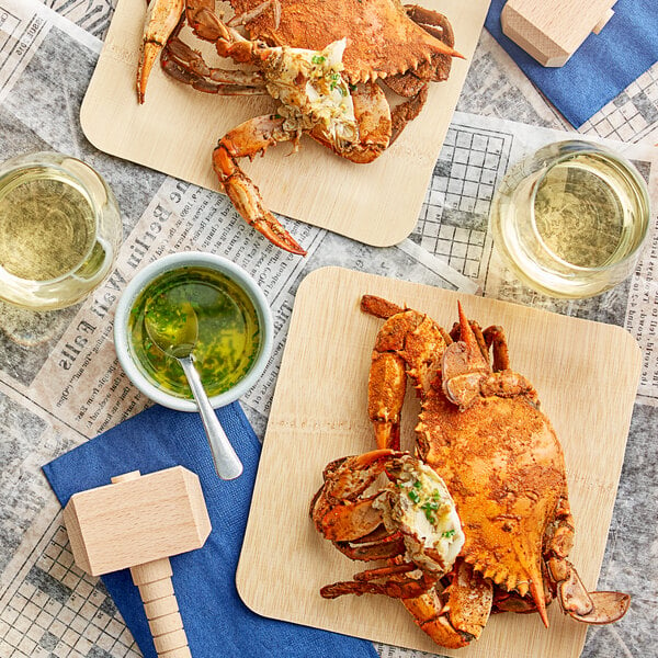 A wooden table with a bushel of steamed Chesapeake female crabs on it.