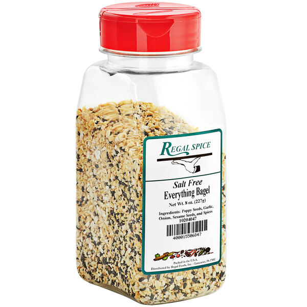 A clear plastic container of Regal Salt-Free Everything Bagel Seasoning with a red lid.