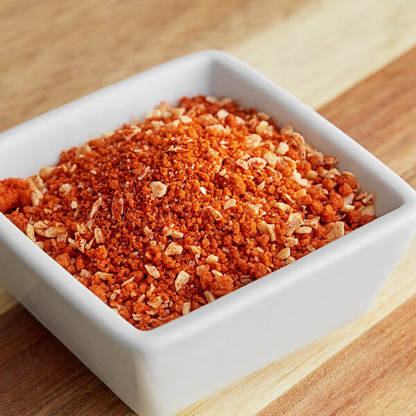 A white square bowl with orange and white powder.