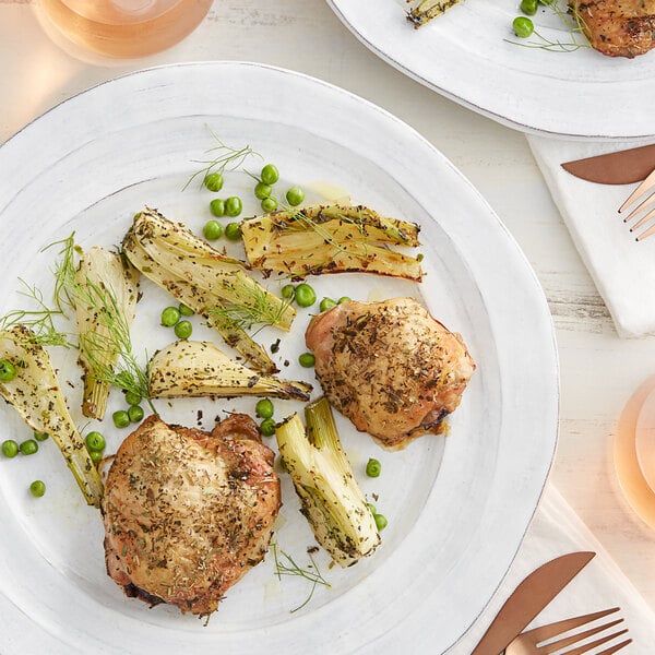 A plate of food with chicken, peas, and carrots seasoned with Regal Herbs de Provence seasoning.