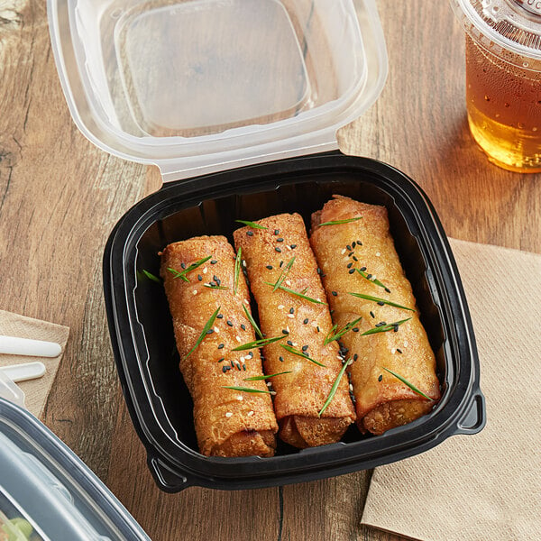 A Choice plastic container with fried food and a drink with a straw on a table.