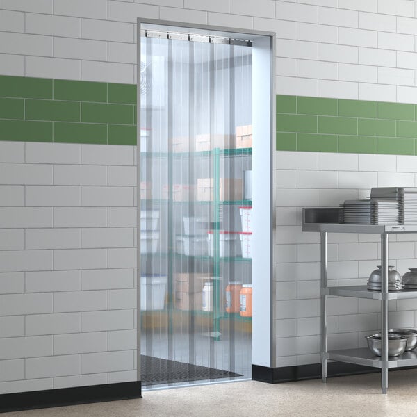 A kitchen door with a clear plastic curtain made from Lavex Polar Strip Door roll.