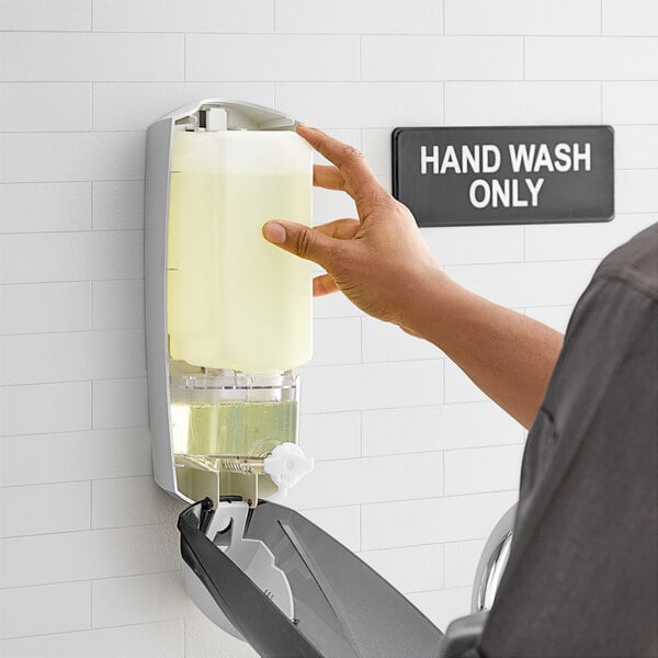 A hand pressing Dial Professional hand soap into a dispenser.