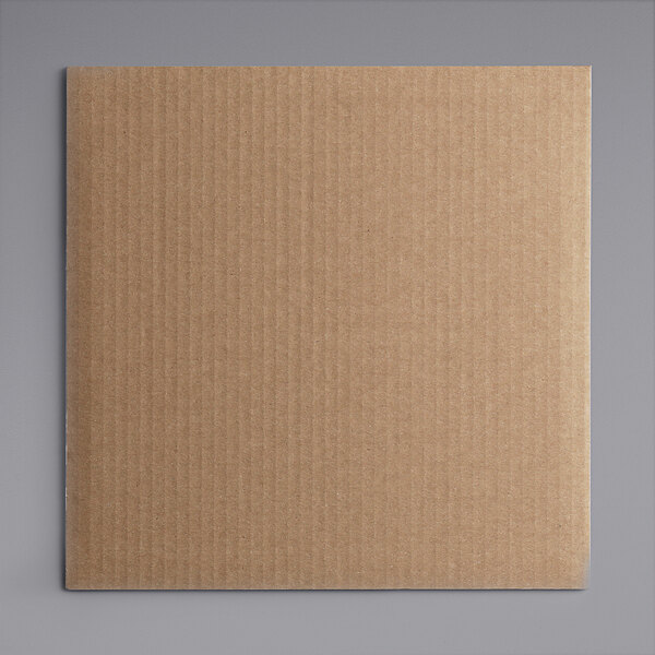 A white corrugated square cake board in a brown cardboard box.