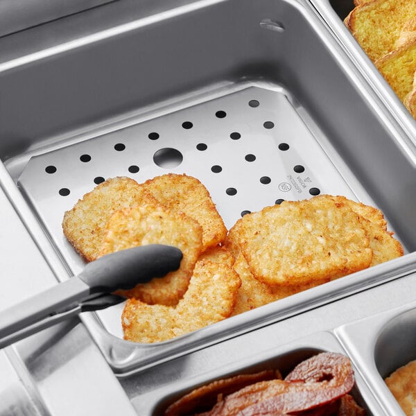 A Vigor stainless steel false bottom in a hotel steam table with food.