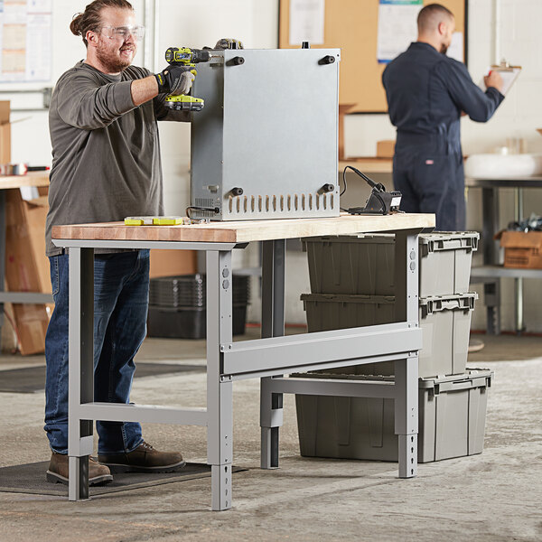 A man using a Lavex maple workbench top to drill a hole.