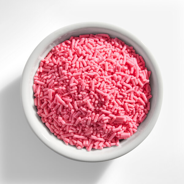 A white bowl filled with pink sprinkles.