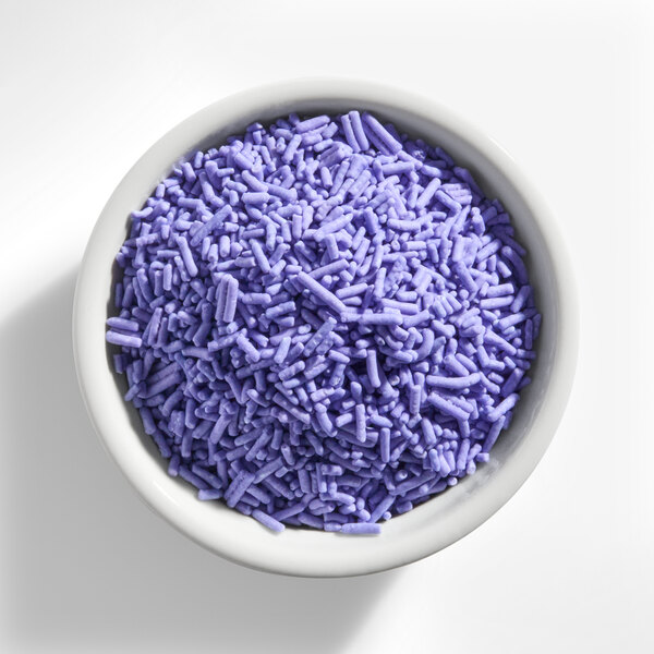 A white bowl filled with purple sprinkles.