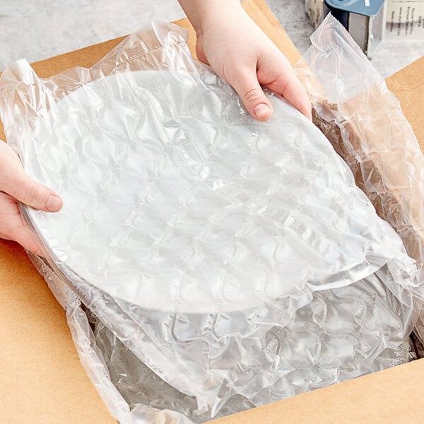 A person holding a Pregis plastic bag of quilted cushion film.