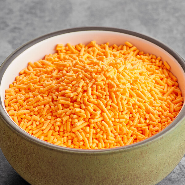 A bowl of orange sprinkles.