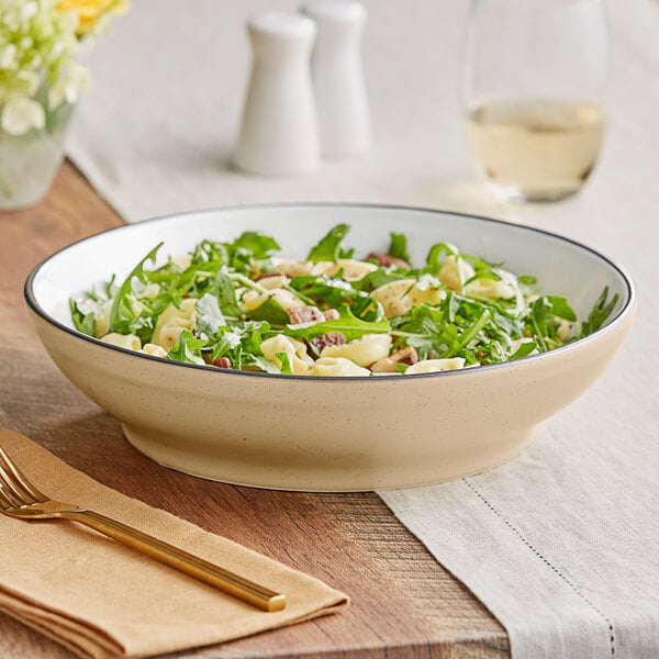 An Acopa Harvest Tan stoneware pasta bowl filled with pasta salad on a table.