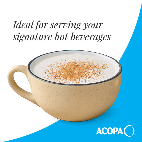 A tan matte stoneware cup filled with a hot beverage and topped with a sprinkle of spice.