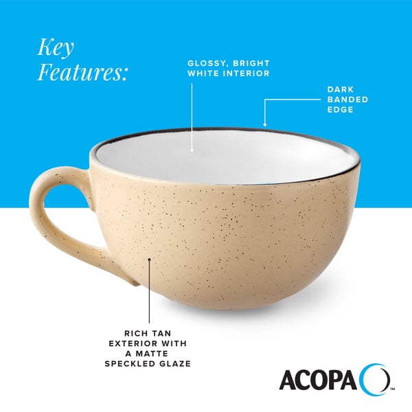A tan matte stoneware cup with a speckled glaze, glossy white interior, and a dark banded edge.