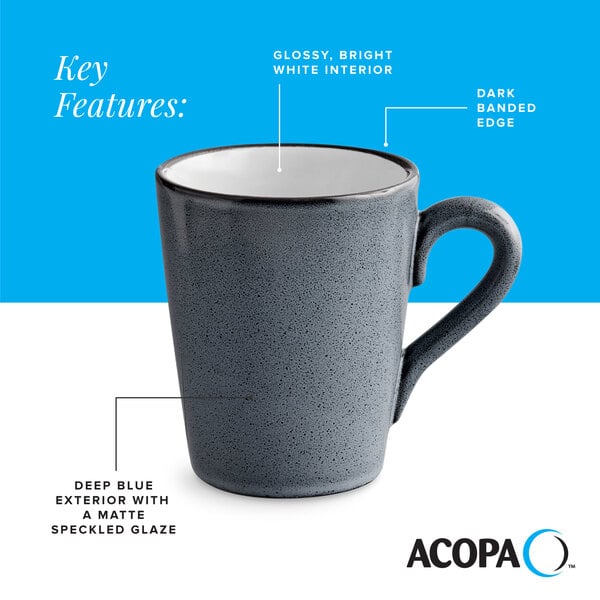 A deep blue matte stoneware mug with a speckled glaze, glossy white interior, and dark banded edge.
