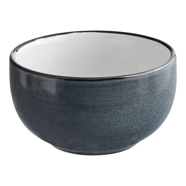 A matte midnight blue stoneware bowl with a white rim.