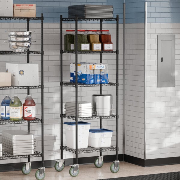 A Steelton black metal wire shelving unit with shelves and casters holding food items.
