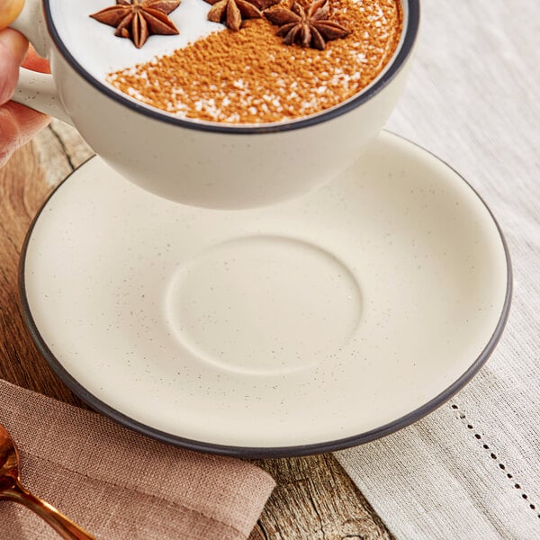 An Acopa Embers stoneware saucer with a cup of coffee with cinnamon and star anise on a table.