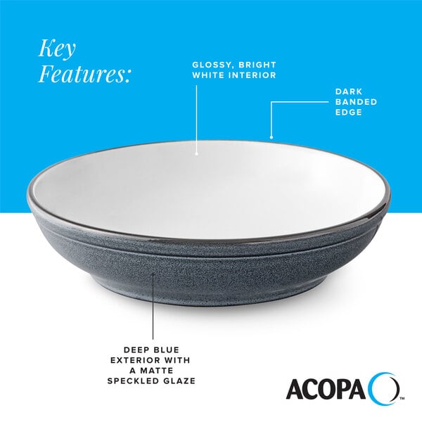 A deep blue matte stoneware pasta bowl with a glossy white interior and dark banded edge.