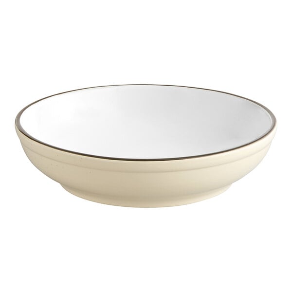 A white stoneware pasta bowl with a black rim.