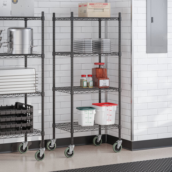 A black epoxy 4-shelf wire shelving unit with casters, used for storage in commercial settings.