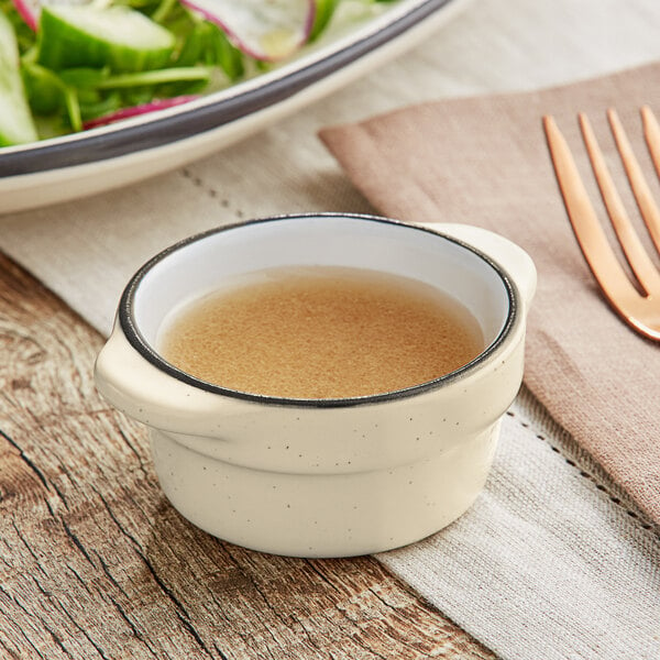 An Acopa Embers stoneware sauce cup filled with brown liquid.