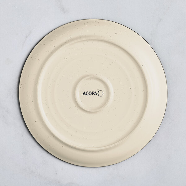 An Acopa cream white stoneware plate with black specks on it.