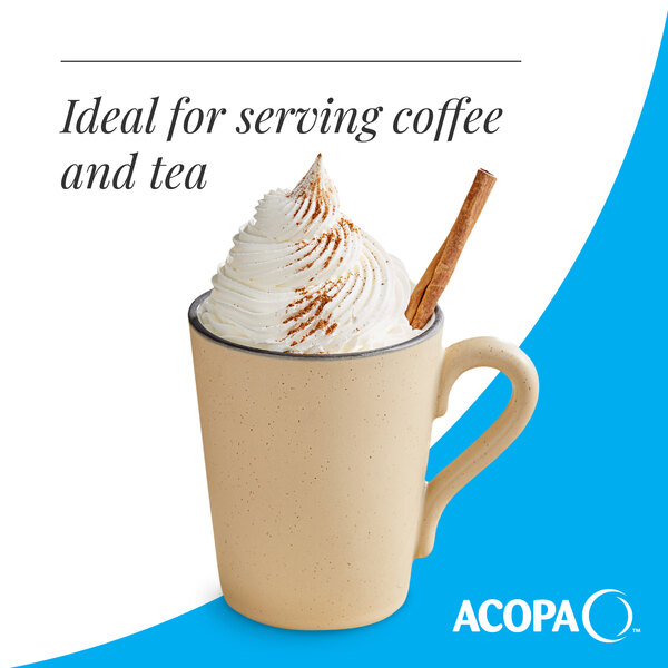 A tan matte stoneware mug filled with a whipped cream-topped beverage and a cinnamon stick.