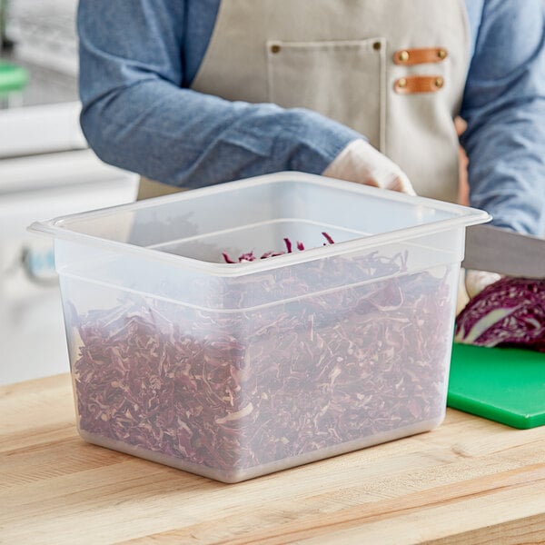 A person cutting cabbage in a Vigor translucent polypropylene food pan.