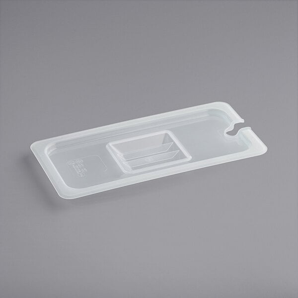 A translucent plastic container lid with a handle and notch.