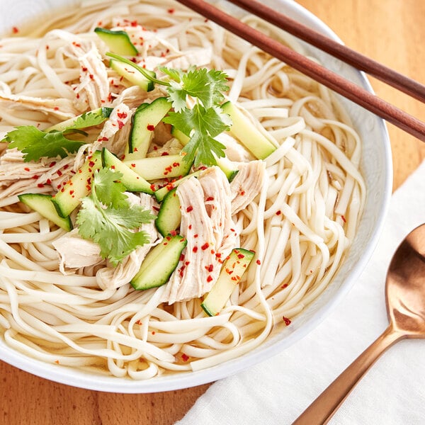 A white bowl of Korean Kal-Guksoo noodles with meat and vegetables.