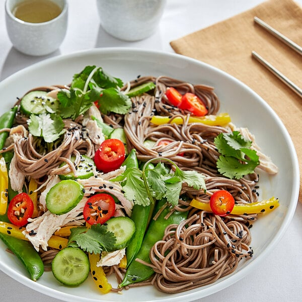 A plate of Buckwheat Noodles with vegetables and cucumbers.