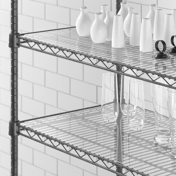 A Regency shelf with white vases and glasses on a clear shelf liner.