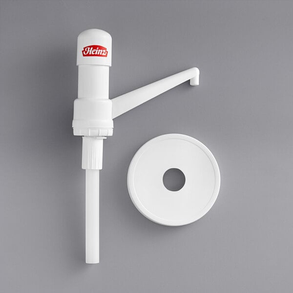 A white plastic pump with a fixed nozzle and dip tube on a white surface.